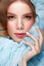 Beautiful girl with light make-up and gentle manicure in blue clothes. Beauty face. Design nails. Royalty Free Stock Photo