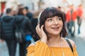 Beautiful girl listens music at street with crowded Royalty Free Stock Photo