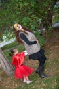 Beautiful girl on little red riding hood costume playing with her mom. Real family having fun while using costumes of the Little Royalty Free Stock Photo