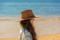 Beautiful girl with long black hair in a cowboy hat on the beach on a sunny day Royalty Free Stock Photo