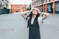 A beautiful girl in a long black sarafan walks down the street. loft style