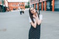 A beautiful girl in a long black sarafan walks down the street. loft style