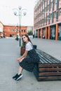 A beautiful girl in a long black sarafan walks down the street. loft style