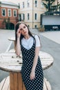 A beautiful girl in a long black sarafan walks down the street. loft style