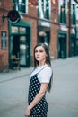 A beautiful girl in a long black sarafan walks down the street. loft style