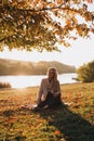 Beautiful girl with long blond hair in autumn landscape at sunset. Autumn portrait of a girl, selective focus Royalty Free Stock Photo