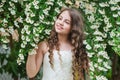Beautiful girl long curly hair spring flowers background, full bloom concept Royalty Free Stock Photo