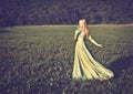 Beautiful girl in long green dress with bouquet of flowers in summer onnature Royalty Free Stock Photo