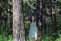 Beautiful girl with long hair in dress walking in woods