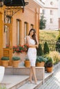 A beautiful girl with long hair and long legs is standing near a beautiful brick building and thinking Royalty Free Stock Photo