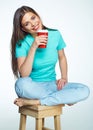 Beautiful girl with long hair sitting on chair with coffee cup.