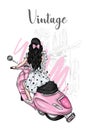 Beautiful girl with long hair in a summer dress sits on a vintage moped. Fashion and style, clothes and accessories. Royalty Free Stock Photo