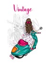 Beautiful girl with long hair in a summer dress sits on a vintage moped. Fashion and style, clothes and accessories. Royalty Free Stock Photo