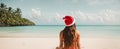 Beautiful Girl with long hair travel a Santa hat against the background sea advertising vacation concept