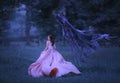 Beautiful girl in a long, pink, fluttering dress runs away from death in the form of a dark demon who came out of hell