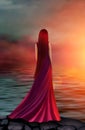 Beautiful girl in a long red dress in the rays of the sunset Royalty Free Stock Photo