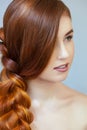 Beautiful girl with long red hair, braided with a French braid, in a beauty salon. Royalty Free Stock Photo