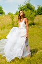 Beautiful girl in long white dress standing on Royalty Free Stock Photo