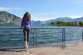 Beautiful girl looking lake and mountains sunny landscape on background outdoor. Travel healthy lifestyle concept.