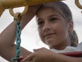 A beautiful girl looks into the distance. Close-up of the face of a teenage girl with a slight smile standing on an iron chain Royalty Free Stock Photo