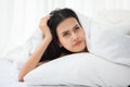 beautiful girl lying down in blanket on bed Thinking something and looking up . Young asian woman waking up early in the morning