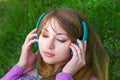 Beautiful girl lying on the grass and listening music Royalty Free Stock Photo