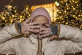 Beautiful girl with a make-up on a background of a golden bokeh, fingers of a hand close a part of the face