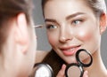 Beautiful girl makes herself a make-up in the mirror. Beauty face. Royalty Free Stock Photo