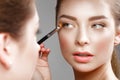 Beautiful girl makes herself a make-up in the mirror. Beauty face. Royalty Free Stock Photo