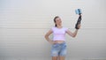 Beautiful girl makes selfie outdoors. teenager is photographed on a smartphone using small tripod. young girl blogger Royalty Free Stock Photo