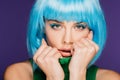 Beautiful girl with makeup posing in blue wig, isolated