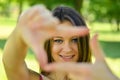 Beautiful girl making frame with hands while outdoors Royalty Free Stock Photo