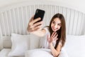 Beautiful girl making selfie in the bed. Beautiful girl making self on the bed at home. Selfie in the morning Royalty Free Stock Photo