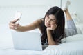 Beautiful girl making selfie on smartphone in the bed at home, T Royalty Free Stock Photo