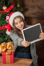 Beautiful girl making selfies on tablet PC near New Year tree Royalty Free Stock Photo