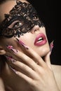 Beautiful girl in a mask with long fingernails. Royalty Free Stock Photo