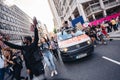 Beautiful girl with megaphone sitting on the top of the van in front of the Huge crowd of Black Lives Matters protesters heading