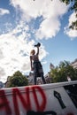 Beautiful girl with megaphone standing on the top of the van in front of the Huge crowd of Black Lives Matters protesters heading
