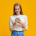 Beautiful Girl Messaging On Smartphone Over Orange Background Royalty Free Stock Photo