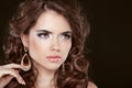 Beautiful girl model with curly long hair and fashion earrings i