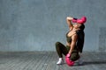 Beautiful girl model posing on camera in boxing gloves in pink light. Girl sitting on the floor on a gray concrete Royalty Free Stock Photo