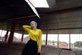 Portrait of beautiful girl with blue hair and red lips in a yellow sweater at the construction site Royalty Free Stock Photo