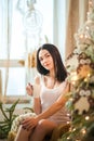 Beautiful girl in the morning with a cup in the New Year`s interior. Woman at home at Christmas time in a bedroom in a rustic styl Royalty Free Stock Photo