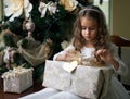 Beautiful girl near Christmas tree unpacking presents Royalty Free Stock Photo