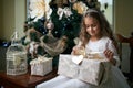 Beautiful girl near Christmas tree unpacking presents Royalty Free Stock Photo