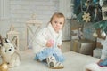 Beautiful girl near decorated Christmas tree with toy wooden rocking horse. Happy new year. Portrait little girl Royalty Free Stock Photo
