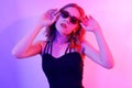 Beautiful girl in neon. Fashion photo of a short-haired girl, dancing, sun glasses. Girl in red and blue light posing Royalty Free Stock Photo