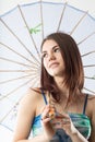 Beautiful girl nicely smiling with a blue Eastern parasol