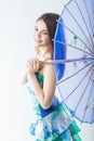 Beautiful girl nicely smiling with a blue Eastern parasol