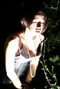 Beautiful girl in night in bush looking on something down, hand